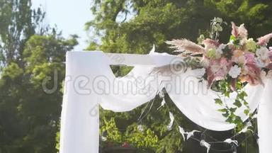 在阳光明媚的夏日，<strong>婚礼</strong>拱门装饰着鲜花。 节日花装饰。 玫瑰和<strong>羽毛</strong>草